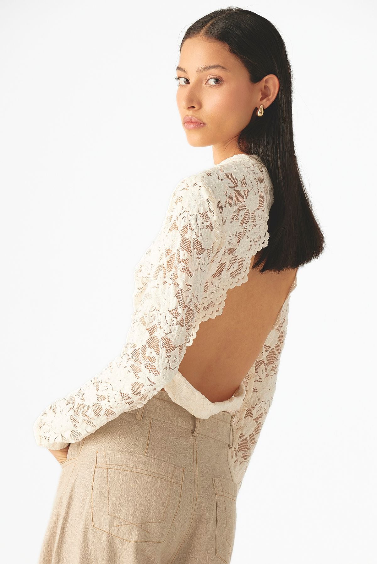 Blusa de encaje floral con cuello alto, mangas largas y silueta ajustada de Mariangélica Guerra.