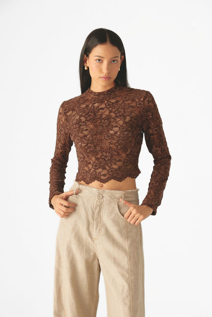 Blusa de encaje floral con cuello alto, mangas largas y silueta ajustada de Mariangélica Guerra.