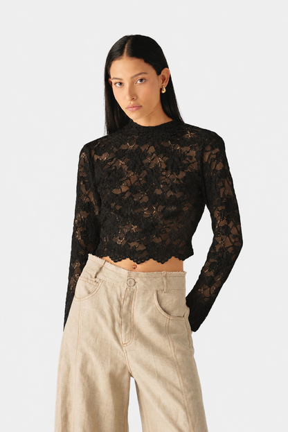 Blusa de encaje floral con cuello alto, mangas largas y silueta ajustada de Mariangélica Guerra.