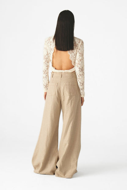 Blusa de encaje floral con cuello alto, mangas largas y silueta ajustada de Mariangélica Guerra.
